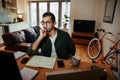 Mixed race businessman working off desktop laptop reading with spetacles while sitting at home office Royalty Free Stock Photo