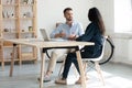 Mixed race colleagues discussing project details in office. Royalty Free Stock Photo