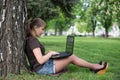 Mixed race college student lying down on the grass working Royalty Free Stock Photo