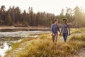 Mixed race couple holding hands, walking near a rural lake Royalty Free Stock Photo