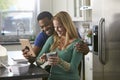 Mixed race couple looking at a tablet computer together in kitchen Royalty Free Stock Photo
