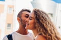 Mixed race couple in love hugging outdoors. Happy arab man kissing white woman in cheek. Romantic relationships