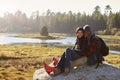 Mixed race couple on a rock in countryside looking to camera Royalty Free Stock Photo