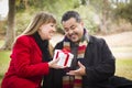 Mixed Race Couple Sharing Christmas or Valentines Day Gift Outdoors Royalty Free Stock Photo