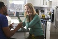 Mixed race couple talking in the kitchen, woman laughing Royalty Free Stock Photo