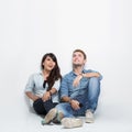 Mixed race couple thinking looking up and sitting on the floor Royalty Free Stock Photo