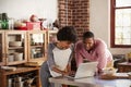 Mixed race couple using laptop computer in their kitchen Royalty Free Stock Photo