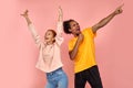 A mixed race couple of young funny and happy dark-skinned man and ginger woman dancing and reading hip-hop at studio on