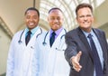 Mixed Race Doctors Behind Businessman Reaching for Hand Shake In