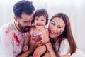 Mixed race family concept. Happy family playing multi color by put to their faces and body with smile and laughing together. Royalty Free Stock Photo