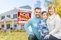 Mixed Race Family In Front of House and Sold For Sale Real Estate Sign Royalty Free Stock Photo