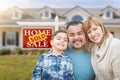 Mixed Race Family In Front of House and Sold For Sale Real Estate Sign Royalty Free Stock Photo