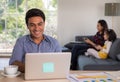 Mixed race family sharing time in living room. Caucasian father using notebook computer to work, half-Thai girl and Asian mother Royalty Free Stock Photo