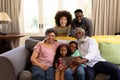 Mixed race family spending time together sitting on a couch Royalty Free Stock Photo