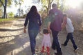 Mixed race family walking on rural path, backlit back view Royalty Free Stock Photo