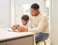 Mixed race father helping his son with his homework. Dad teaching son to read and write during homeschool class. Little Royalty Free Stock Photo