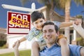 Mixed Race Father, Son Piggyback, Front of House, Sold Sign Royalty Free Stock Photo