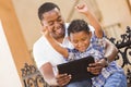 Mixed Race Father and Son Using Touch Pad Tablet Royalty Free Stock Photo