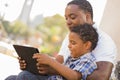 Mixed Race Father and Son Using Touch Pad Tablet Royalty Free Stock Photo