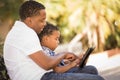 Mixed Race Father and Son Using Touch Pad Tablet Royalty Free Stock Photo