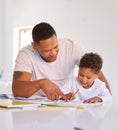 Mixed race father teaching little son during homeschool class at home. Cute little hispanic boy learning how to read and Royalty Free Stock Photo