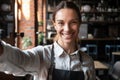 Mixed race female in apron smiling looking at web camera Royalty Free Stock Photo