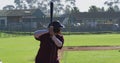 Mixed race female baseball player, hitter, swinging bat for pitched ball