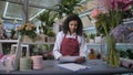 Cute flowergirl accepting orders in floristic shop