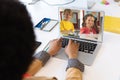Mixed race female teacher using laptop on video call with school children learning from home Royalty Free Stock Photo