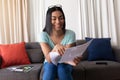 Mixed race gender fluid man working at home making video call reading documents and smiling Royalty Free Stock Photo