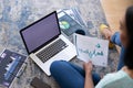 Mixed race gender fluid man working at home sitting on floor using laptop, copy space screen Royalty Free Stock Photo