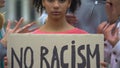 Mixed-race girl holds sign No racism, suffers crowd screaming racial insults