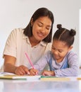 Mixed race girl learning and studying in homeschool with mom. Woman helping her daughter with homework and assignments Royalty Free Stock Photo