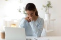 Gloomy young woman sitting at desk looking at computer screen Royalty Free Stock Photo