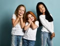 Mixed race international kids emotional girls in jeans and white t-shirts stand together melting feeling touched love