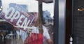 Mixed race male barista with dreadlocks closing the door and switching the sign from open to closed