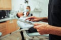 Mixed race male doctor assessing female assistant on digital tablet while evaluating male client teeth