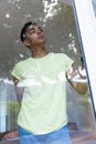 Mixed race man looking through a window and thinking Royalty Free Stock Photo