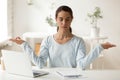 Mixed race mindful female employee doing breathing yoga exercises. Royalty Free Stock Photo