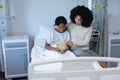 Mixed race mother comforting her sick daughter holding teddy bear in hospital bed Royalty Free Stock Photo