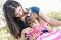 Mixed Race Mother and Cute Toddler Daughter Playing with Cell Phone