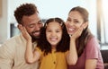 Mixed race parents enjoying weekend with daughter in home living room. Smiling hispanic girl hugging and bonding with Royalty Free Stock Photo