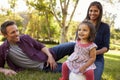 Mixed race parents and young daughter sit in park, close up Royalty Free Stock Photo