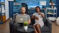 Mixed race people sitting together on sofa expecting baby Royalty Free Stock Photo