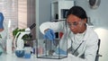 Mixed race research scientist providing experiment with lab mouse by giving it some doze of medicine