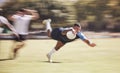 Mixed race rugby player diving to score a try during a rugby match outside on a field. Hispanic male athlete making a Royalty Free Stock Photo