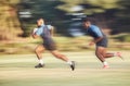 Mixed race rugby player running away from an opponent while attempting to score a try during a rugby match outside on a Royalty Free Stock Photo