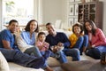 African American , three generation family sitting on sofa in the living room together, eating popcorn and looking to camera, clos Royalty Free Stock Photo