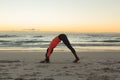 Mixed race woman on beach practicing yoga during sunset Royalty Free Stock Photo