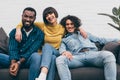 mixed race woman embracing two smiling male friends